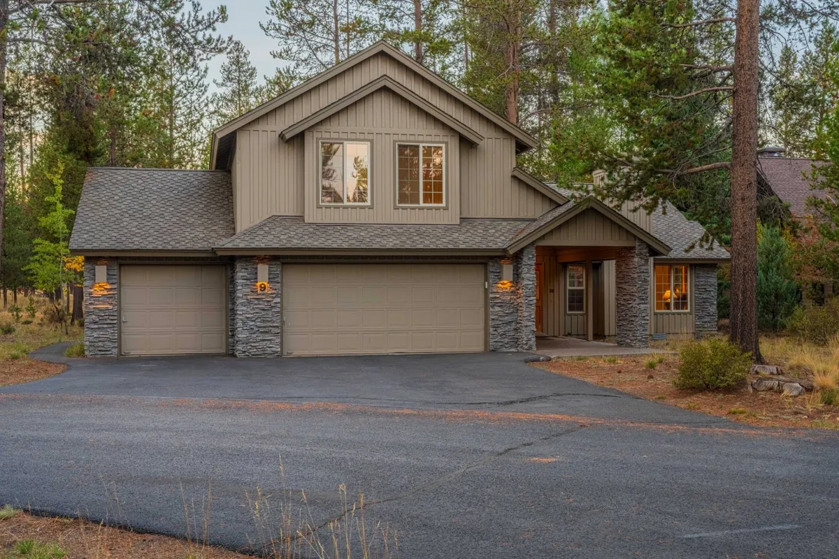 This photo presents the front entrance of the home, showing garage doors, attractive window designs, and mature trees around the property. The inviting facade suggests a warm welcome for gatherings and events.